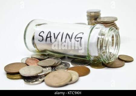 Etichetta di risparmio in un vasetto di vetro con monete fuoriuscita Foto Stock