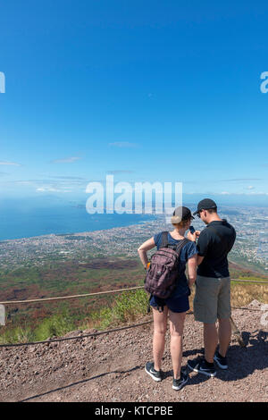 Coppia giovane guardando la vista della città di Napoli e il golfo di Napoli dalla vetta del Monte Vesuvio, Napoli, campania, Italy Foto Stock
