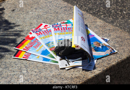 Libera di prendere gli agenti di viaggio brochure steso su una lastra di marmo nella strada principale di Playa de las Americas in Tenneriffe Foto Stock