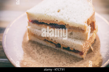 Burro di arachidi e gelatina in sandwich di pane bianco, tagliato a metà e impilati. Mostrato sulla piccola piastra vintage Foto Stock