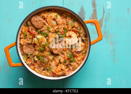 Una ghisa vaso riempito con Jambalaya su una tabella di turchese. Foto Stock