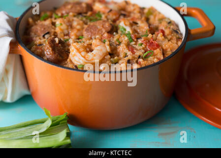 Una ghisa vaso riempito con Jambalaya su una tabella di turchese. Foto Stock