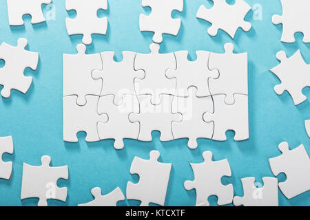 White Jigsaw Puzzle su sfondo blu Foto Stock