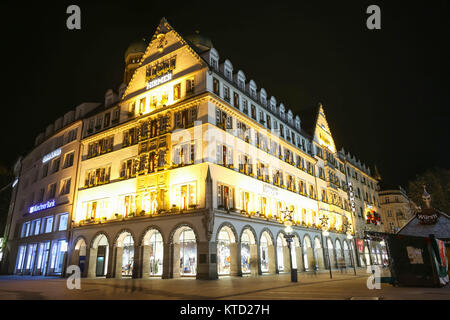 Monaco di Baviera, Germania - 11 dicembre 2017 : una vista del gusto illuminato esterno dell'Hirmer department store di notte a Monaco di Baviera, Germania. Foto Stock