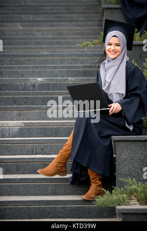 Piuttosto giovane laureato femmina indossa hijab Foto Stock