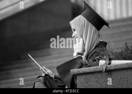 Piuttosto giovane laureato femmina indossa hijab Foto Stock