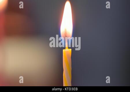 Tessitura macro di bruciare colorati torta di compleanno candele Foto Stock