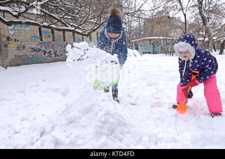 Città dopo la bufera di neve. I bambini aiutano i pazienti adulti per rimuovere neve e ghiaccio da un cantiere di Kyiv. Il 12 gennaio 2016. Kiev, Ucraina. Foto Stock