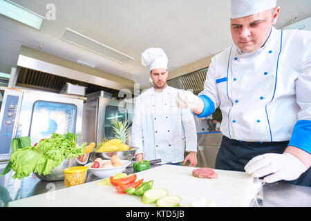 Lo chef prepara il cibo del ristorante cucina Foto Stock