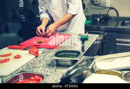Lo chef del ristorante guarnendo il piatto di verdure, prodotto sulle mani, immagine filtrata Foto Stock
