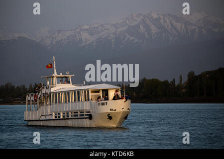 Un privato yacht crociere al tramonto sul Kirghizistan Issyk-Kul lago vicino la città di Karakol. Foto Stock