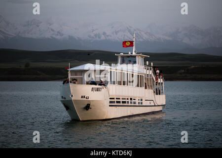 Un privato yacht crociere al tramonto sul Kirghizistan Issyk-Kul lago vicino la città di Karakol. Foto Stock