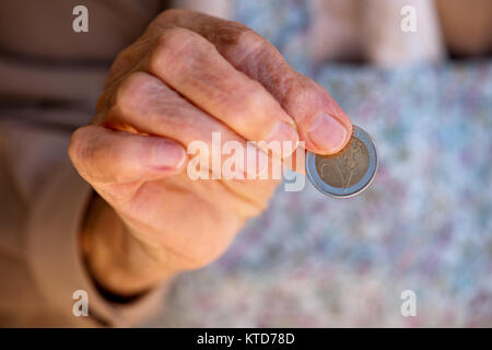 Anziana donna caucasica tenendo il denaro nelle sue mani Foto Stock