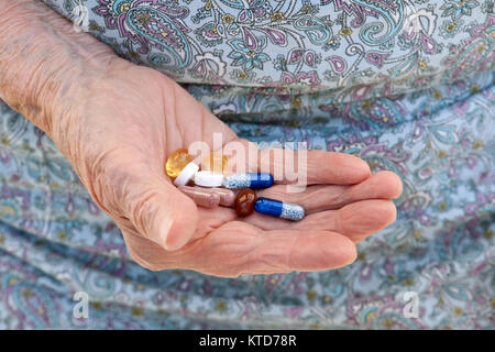 Anziana donna caucasica holding medicinali nelle sue mani Foto Stock