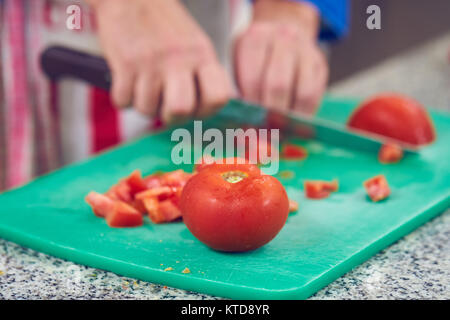 Chef di versare le spezie sul piatto in cucina commerciale Foto Stock