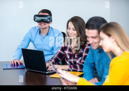 Team di persone motivate, utilizzando vari dispositivi ad una fusione di avvio. concetto, il lavoro di squadra Foto Stock