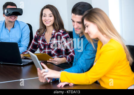 Team di persone motivate, utilizzando vari dispositivi ad una fusione di avvio. concetto, il lavoro di squadra Foto Stock