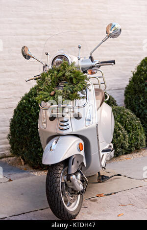 Una ghirlanda di Natale pende da una scooter Vespa parcheggiata di fronte una casa storica lungo Church Street a Charleston, Sc. Foto Stock