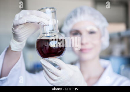 Scienziato in laboratorio pallone di contenimento con il liquido Foto Stock