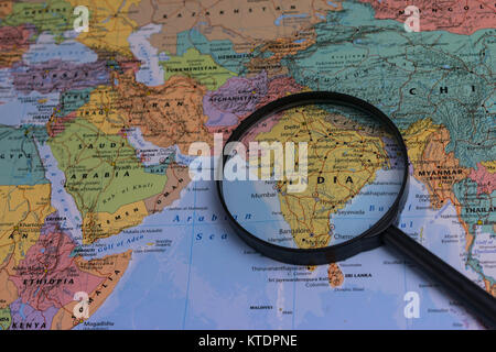 Mappa di India attraverso la lente di ingrandimento su una mappa del mondo Foto Stock