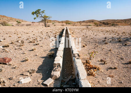 Vecchio trogolo di pietra nel paesaggio - Huab sotto tela, Damaraland, Namibia, Africa Foto Stock