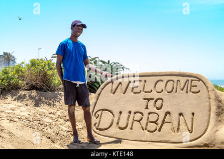 DURBAN, Sud Africa - 02 novembre 2017: sconosciuta la scultura di sabbia builder a bay abbondanza a Durban si erge accanto alla sua opera e punti a. Foto Stock