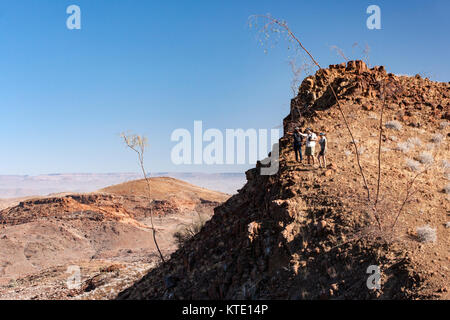 I turisti su cliff's edge in Damaraland - Huab sotto tela, Damaraland, Namibia, Africa Foto Stock