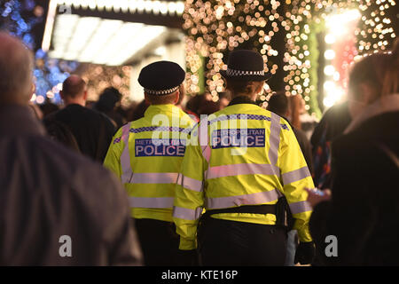 Metropolitan ufficiali della polizia di pattuglia sulla Oxford Street a Londra durante il periodo natalizio. Foto Stock