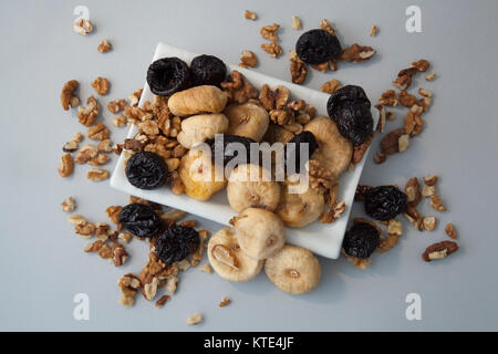 Frutta secca fichi e prugne su sfondo di legno Foto Stock