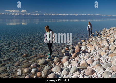 Due donne turisti della metà degli anni 20 camminano lungo la riva meridionale del lago Issyk-Kol in Kirghizistan. Foto Stock