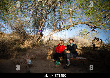 Due turisti femminili seduti accanto ad una sorgente Santa nel luogo di pellegrinaggio Manjyly-ATA nell'oblast Issyk-Kol del Kirghizistan. Foto Stock