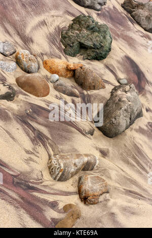 Sabbia colorata e pietre sulla spiaggia con la bassa marea, Andrew Molena State Park, California, Stati Uniti d'America Foto Stock