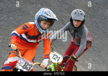 Ragazza Preteen conduce i ragazzi in una gara. Piloti a Kettering BMX gara in notturna. BMX via, Delco Park, Kettering, Dayton, Ohio, Stati Uniti d'America. Foto Stock