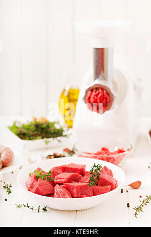 Tritate la carne cruda. Il processo di preparazione di forcemeat per mezzo di un tritacarne. Salsiccia casalinga. Macinato di manzo. Foto Stock