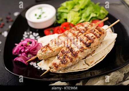 Macinate kebab di Lula tacchino alla griglia (pollo) con verdure fresche. Foto Stock