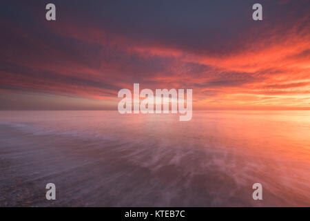 Molto luminoso rosso tramonto sul mare a Seaford, vicino Newhaven, Sussex, Regno Unito. Red Sky di notte; pastore del piacere! Foto Stock