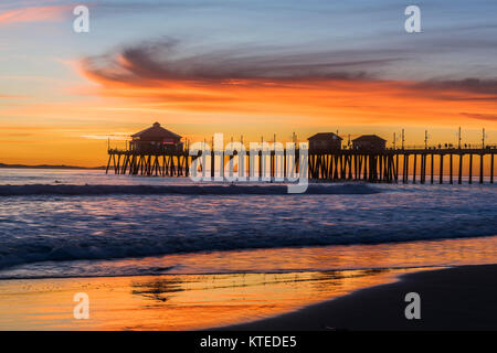 Paesaggio surreale come il sole tramonta sotto l'orizzonte lungo Huntington Beach, colata di un bagliore bellissimo e tranquillo paesaggio. Foto Stock