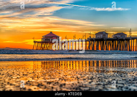 Paesaggio surreale come il sole tramonta sotto l'orizzonte lungo Huntington Beach, colata di un bagliore bellissimo e tranquillo paesaggio. Foto Stock