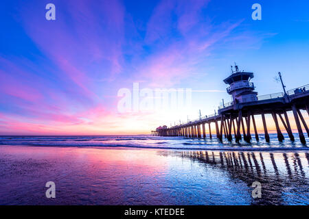 Paesaggio surreale come il sole tramonta sotto l'orizzonte lungo Huntington Beach, colata di un bagliore bellissimo e tranquillo paesaggio. Foto Stock