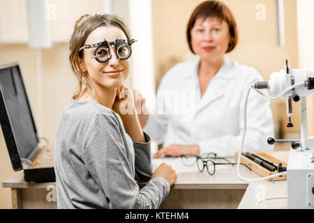Ritratto di una giovane donna paziente con il senior oculista durante la consultazione in ufficio Foto Stock