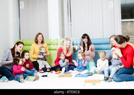 Le madri con figli battano le mani e gioca Foto Stock