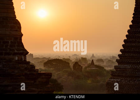 Silhouette di molte pagode e templi e sunrise sulle misty pianura di Bagan, Myanmar (Birmania), viste leggermente dall'alto. Foto Stock