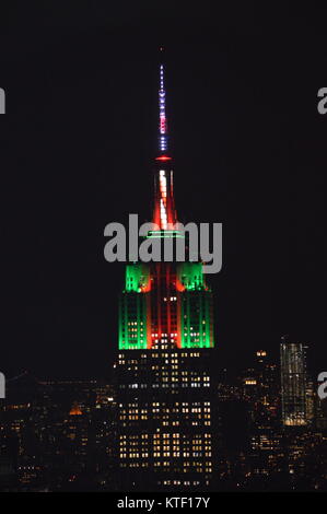 New York, Stati Uniti d'America. 23 Dic, 2017. La vista dell'Empire State Building è illuminato in verde e rosso con un candy cane antenna nella celebrazione del Natale. Foto Stock