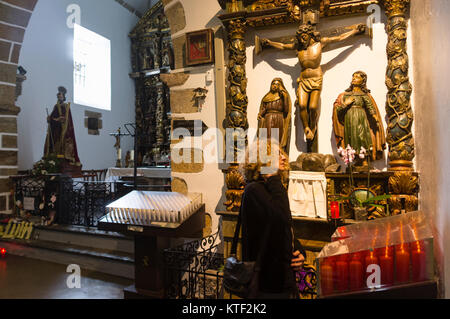 Donna fedele accendendo candele presso il santuario di San Andres de Teixido, un importante luogo di pellegrinaggio per i galiziani. Cedeira, Coruna prov Foto Stock