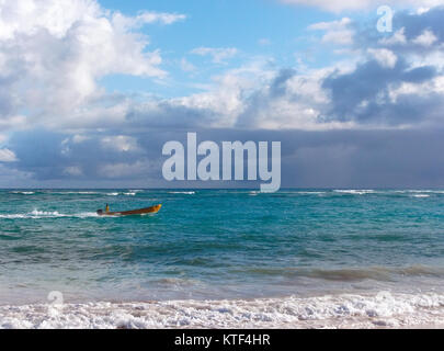 Punta Cana, Repubblica Dominicana, Dicembre 15, 2014: un uomo aziona una barca di colore giallo. Foto Stock