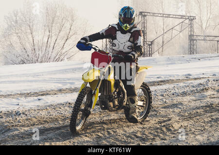 Protettivo per motociclisti Enduro marcia nella neve sporco su una pista di motocross in inverno. Extreme Motorsports. Racer va fuori strada. Divertimento estremo in win Foto Stock