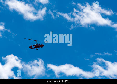 Un girocopter microleggero che si staglia contro un cielo blu, volando a Sydney, Australia Foto Stock