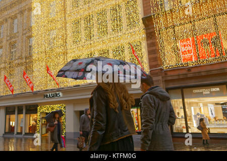Glasgow, Scotland, Regno Unito 24 Dicembre.UK Meteo: pioggia e vento salutare i last minute la vigilia di Natale gli amanti dello shopping a Buchanan Street, Glasgow stile del miglio da Fraser o le strade di princes Square Shopping Centre. Credito traghetto Gerard/Alamy news Foto Stock
