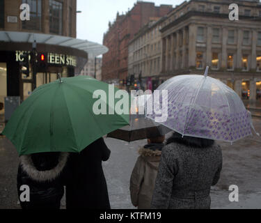 Glasgow, Scotland, Regno Unito 24 Dicembre.UK Meteo: pioggia e vento salutare i last minute la vigilia di Natale gli amanti dello shopping a Buchanan Street, Glasgow stile del miglio da Fraser o le strade di princes Square Shopping Centre. Credito traghetto Gerard/Alamy news Foto Stock