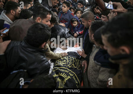 La striscia di Gaza, la Palestina. 24 dicembre, 2017. Palestinesi in lutto al di sopra del corpo di 19-anno-vecchio Mohamed Sami al-Dahdouh, durante il suo funerale di Gaza City, nella Striscia di Gaza e i territori palestinesi, 24 dicembre 2017. Al-Dahdouh è stato ucciso durante gli scontri con i soldati israeliani a seguito delle proteste contro il presidente statunitense Donald Trump per la decisione di riconoscere Gerusalemme come capitale di Israele. Foto: Wissam Nassar/dpa Credito: dpa picture alliance/Alamy Live News Foto Stock